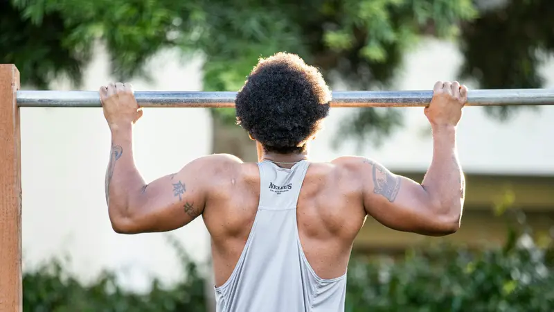 Athlete mid pull-up on an outdoor bar — tennis elbow physical therapy guide at Forward Physio Tampa